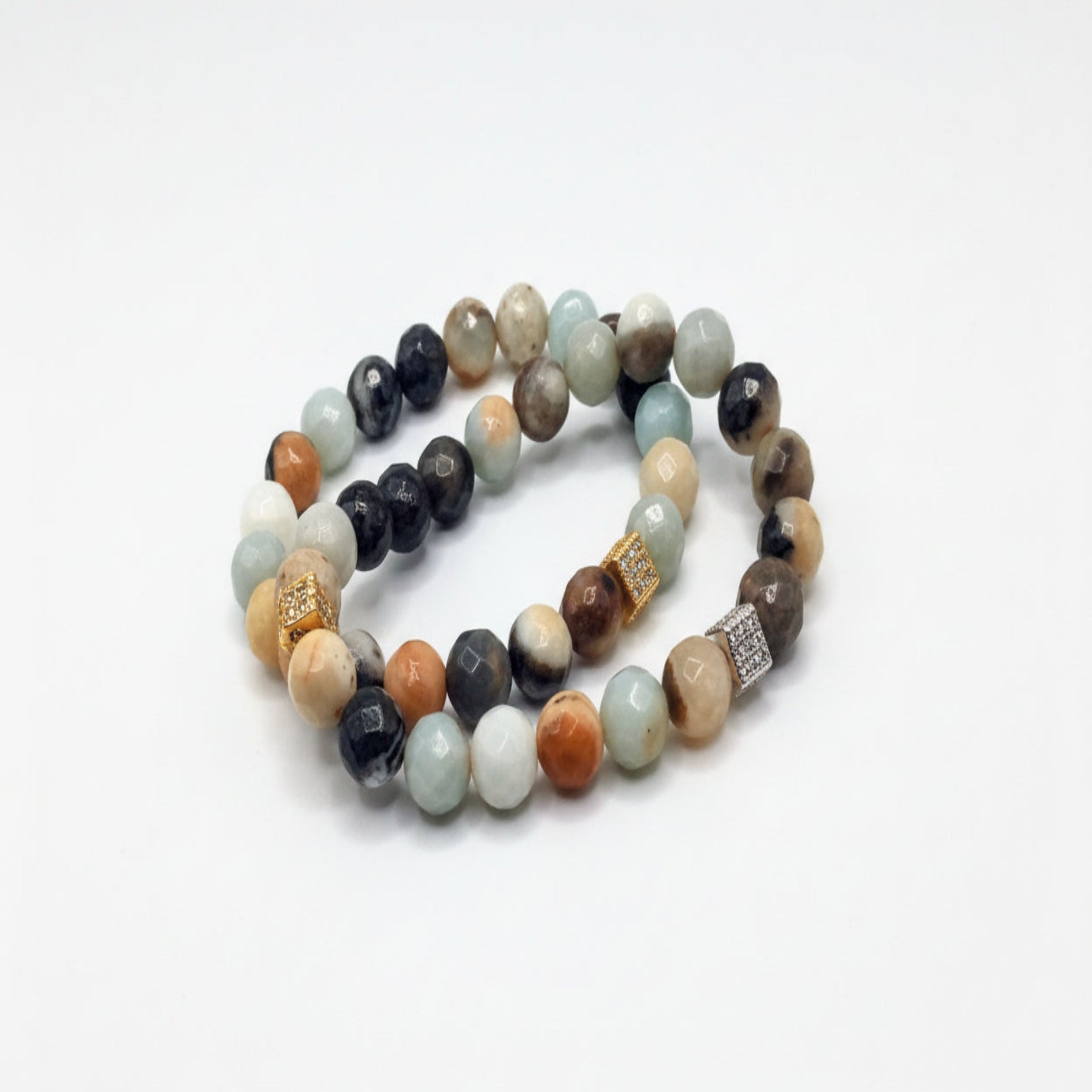 Stack of multicolored beaded bracelets on a white background